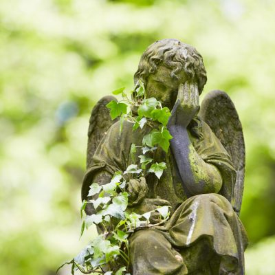 Sad angel statue on old cemetery